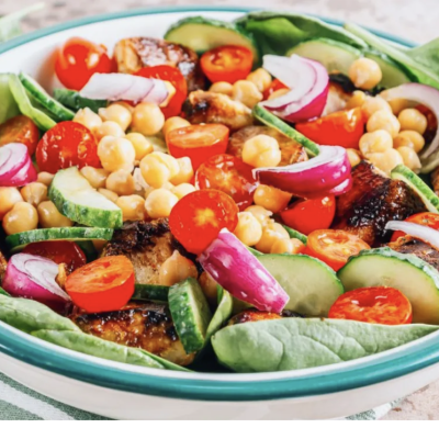 Bowl with salad, beans, chicken, cucumbers, tomatoes