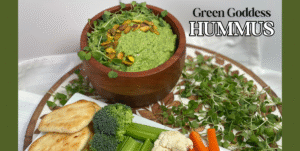 Green goddess hummus feature image with hummus in wood bowl on tray with dipping options like bread and raw veggies