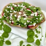 Spring Garden farro salad with radishes, goat cheese, lettuce and watercress in wood bowl