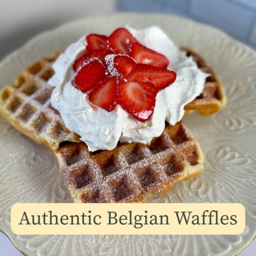 Authentic Belgian Waffles cover image with white plate, 3 Belgian waffles on it topped with whipped cream and sliced strawberries.