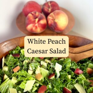Four peaches above a peach caesar salad in a wood bowl